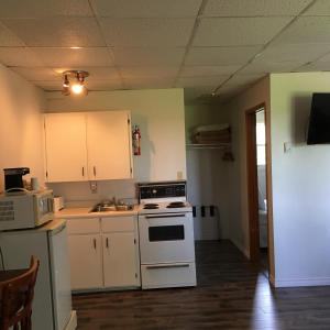 a kitchen with white cabinets and a stove top oven at Canadas Best Value Inn & Suites Summerside in Summerside