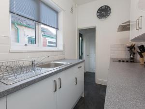 a kitchen with a sink and a clock on the wall at Townhouse @ Newlands Street Stoke in Etruria