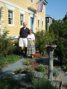a man and a woman standing in front of a house at Newport House Bed & Breakfast in Williamsburg