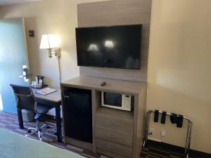 a hotel room with a desk and a flat screen tv at SureStay Hotel by Best Western Fort Pierce in Fort Pierce