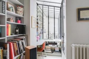 a room with bookshelves and a desk and a window at Sumptuous house with patio in Paris