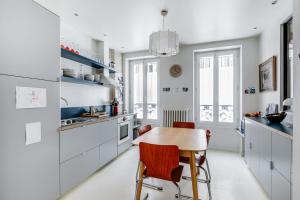 een keuken met witte kasten en een houten tafel bij Sumptuous house with patio in Parijs