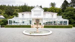 a large white house with a fountain in front of it at Plas Maenan in Conwy