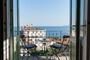 uma varanda com uma mesa e cadeiras e o oceano em Luxury Peitho Residence em Opatija