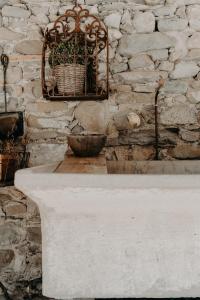 una pared de piedra con una mesa y una cesta en l'Herbier - chambre d'Hôtes - en Marnaz