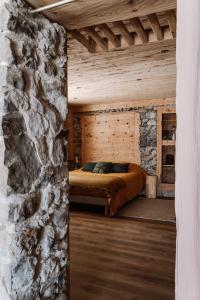l'Herbier - chambre d'Hôtes - في Marnaz: غرفة نوم بسرير في جدار حجري