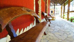 a wooden bench with a bird head on a wall at Pousada Arapassu in Eldorado