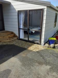 a sliding glass door in a house with a porch at J&D Cottage in Kerikeri