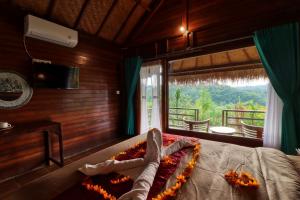 a bedroom with a bed and a large window at Ayu Hill Bungalows in Nusa Penida