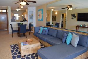 sala de estar con sofá azul y mesa en Menehune Shores 309, en Kihei