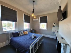 1 dormitorio con 1 cama con sábanas azules y ventanas en The Royal Hotel, en Muswellbrook 15 fotos más