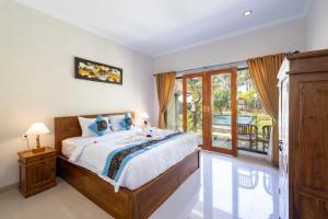 a bedroom with a large bed and a balcony at Surya Maha Bungallo in Nusa Penida