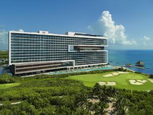 a large white building sitting on top of a lush green hillside at Dreams Vista Cancun Golf & Spa Resort in Cancún