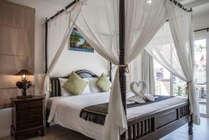 a bedroom with a canopy bed and a window at Poonsiri Private Pool Villa Aonang in Ao Nang Beach +64 photos