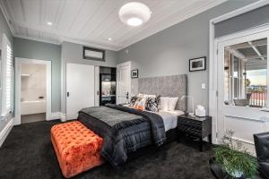 a bedroom with a bed with an orange ottoman at Franklin38 in Auckland