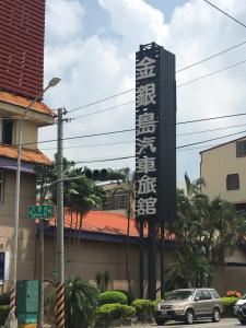 a sign for a hotel in front of a building at Treasure Island Motel - Renwu in Kaohsiung