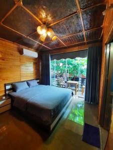 a bedroom with a large bed and a large window at Cò's House in Mai Chau