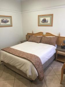 a bedroom with a large bed in a room at Midway Inn Hotel in Middelburg