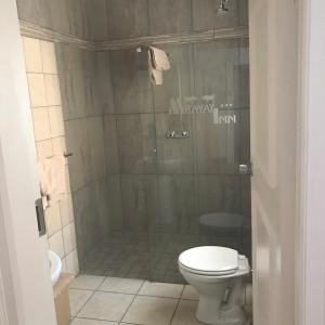 a bathroom with a toilet and a shower at Midway Inn Hotel in Middelburg