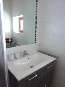 ein Badezimmer mit einem weißen Waschbecken und einem Spiegel in der Unterkunft Ferienwohnung Sir in Sillian