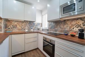 a kitchen with white cabinets and a microwave at El Coso Boutique Lucena in Lucena