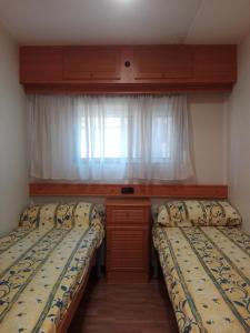 En eller flere senge i et værelse på Camping Bungalows Sol D´Or