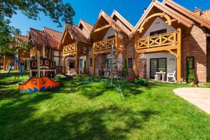 une maison avec une aire de jeux dans la cour dans l'établissement Domki Hallerowka Resort, à Władysławowo