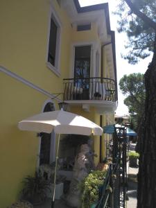 un bâtiment jaune avec un parapluie devant lui dans l'établissement South Garda Suites, à Desenzano del Garda