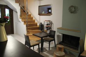 a living room with a table and a fireplace at Tsarbou Guesthouse in Stemnitsa