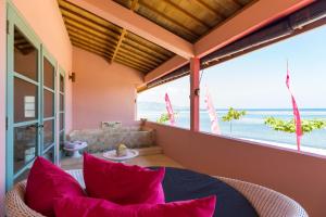 a living room filled with furniture and a balcony at PinkCoco Gili Air in Gili Islands
