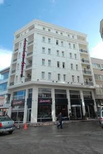 a man walking in front of a white building at Sapci Prestige Hotel in Kesan