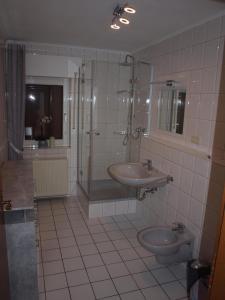 a bathroom with a sink and a shower and a toilet at Ferienwohnung Pasch-Wittke in Geldern