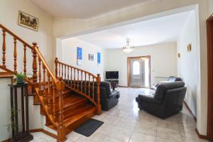 a living room with a staircase and two chairs at Casa da Bene - House Near the Amorosa Beach with Seaview in Viana do Castelo