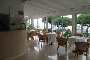 a dining room with tables and chairs and windows at Hotel Toscana in Marotta