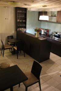un ristorante con bancone, tavoli e sedie di Tsarbou Guesthouse a Stemnitsa