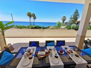 a dining table with a view of the ocean at Villa Arenile - Seaside - Swimmingpool- Private access to Sea - waterfront - Fontane Bianche - Siracusa in Fontane Bianche