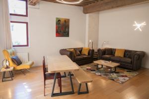 a living room with couches and a table and chairs at Spacieux appartement, A-mi-chemin, au coeur de Tournus in Tournus