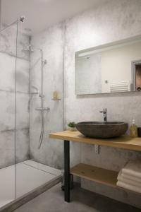 a bathroom with a sink and a glass shower at Spacieux appartement, A-mi-chemin, au coeur de Tournus in Tournus +18 photos