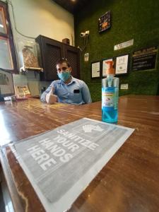 a person wearing a face mask and a bottle of mouthwash at Hotel Jai Surya in Patiāla