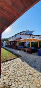 a pavilion with a stone patio with a building at Pagini Din Vama in Vama Veche
