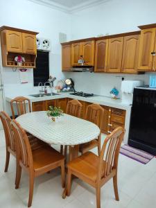 a kitchen with a table and chairs in a kitchen at Zeeyad Homestay dan Roomstay in Kuala Terengganu