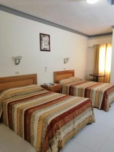 a hotel room with two beds in a room at Hotel Astromundo in Reynosa