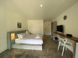 a bedroom with a bed and a desk and a television at Island Dive Club in Koh Tao