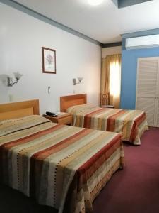 a hotel room with two beds in a room at Hotel Astromundo in Reynosa
