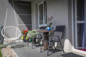 een patio met een tafel, stoelen en bloemen bij Dream Apartment in Suwałki