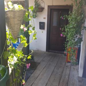 a front porch with flowers and a wooden door at Come to M2 in Zagreb