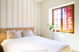 a bedroom with a white bed and a window at CHALET EN PLAYA DE CABAÑAS in Cabañas