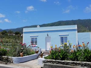 un bâtiment blanc avec des fleurs devant dans l'établissement Casa Celia - Casitas Las Abuelas - Relax rural, à Breña Alta