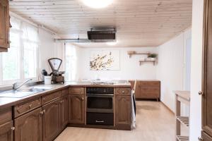 a kitchen with wooden cabinets and a stove top oven at Villa Donkey Ferienwohnung 113 in Degersheim