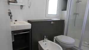 a bathroom with a toilet and a sink and a shower at Portofelice Camping Village in Eraclea Mare